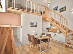 eine Küche und ein Esszimmer mit einem Holztisch und einer Treppe in der Unterkunft Alpine Apartment Pia 6 - Bad Mitterndorf by AA Holiday Homes in Bad Mitterndorf