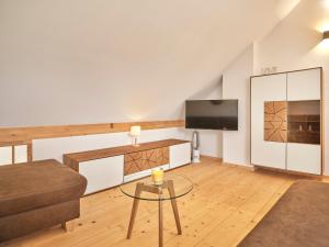 ein Wohnzimmer mit einem Sofa und einem TV in der Unterkunft Alpine Apartment Pia 6 - Bad Mitterndorf by AA Holiday Homes in Bad Mitterndorf