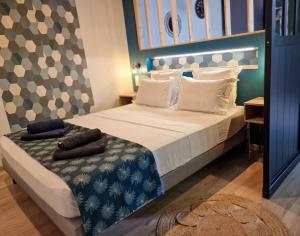 una camera da letto con un grande letto con lenzuola e cuscini bianchi di Le Barachois City a Saint-Denis