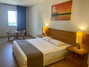 a hotel room with a bed and a table and a window at Caesar Hotel Ramallah in Ramallah