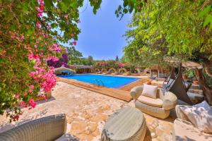 a swimming pool with some chairs and flowers at La Salvia Hotel Kas in Kaş