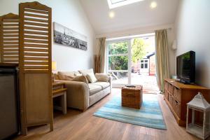 a living room with a couch and a tv at The Garden Suite Annex, Hoole by Rework Accommodation in Chester