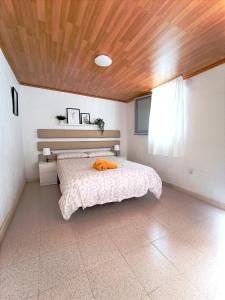 - une chambre avec un lit et un plafond en bois dans l'établissement B&B and Apartments El Charco Azul, à El Risco