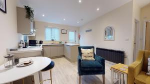 a kitchen and living room with a table and a chair at Primera Barn in Witney