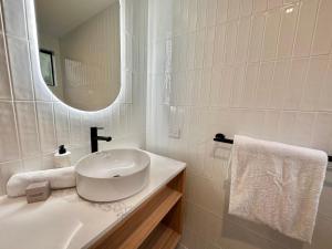 Baño blanco con lavabo y espejo en Chambré Estate, en Margaret River Town