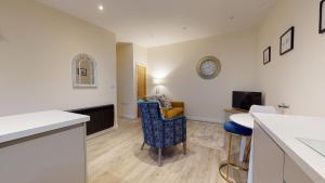 a kitchen and living room with a counter and a table at Primera Barn in Witney