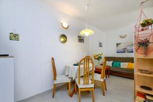 a living room with a table and chairs and a couch at Apartments Marija in Mali Lošinj