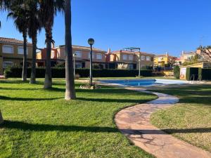 a walkway in a park with palm trees and houses at Villa Mont-roigh in Tarragona
