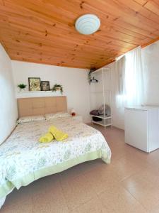1 dormitorio con 1 cama con techo de madera en B&B and Apartments El Charco Azul, en El Risco