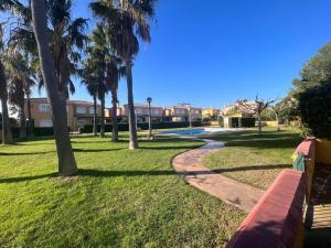 a park with a red bench and palm trees at Villa Mont-roigh in Tarragona