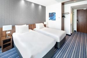 een hotelkamer met 2 bedden en een deur bij Holiday Inn Express Arnhem, an IHG Hotel in Arnhem