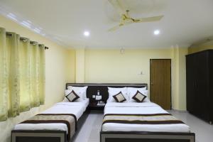 two beds in a room with yellow walls at DREAM STAYS - NEAR AlRPORT in Chennai