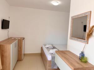 a small room with a bed and a mirror at Camere de inchiriat Sibel in Costinesti