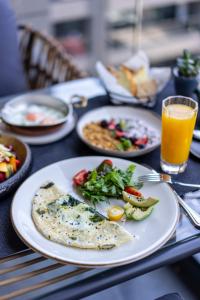 a table with plates of food and a glass of orange juice at The Westin Istanbul Nisantasi in Istanbul