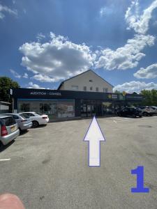 a parking lot with an arrow pointing to a building at L'appartement in Pontarlier