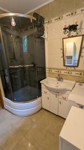 La salle de bains est pourvue d'une douche et d'un lavabo. dans l'établissement Dom letniskowy Sami Swoi, 