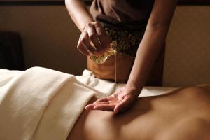a woman is getting her back acupunctureived with a towel at The Westin Istanbul Nisantasi in Istanbul