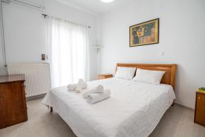 - une chambre avec un lit blanc et des serviettes dans l'établissement Izabella's House Naxos, à Mélanes