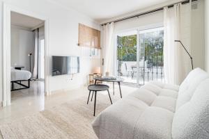 ein weißes Wohnzimmer mit einem Sofa und einem Tisch in der Unterkunft Fully Renovated Modern 2 bedroom apartment in Aloha Pueblo in Marbella