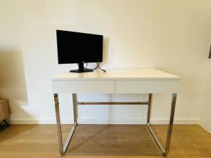 a white desk with a computer monitor on top of it at Spacious Flat, Fast WiFi, Free Parking in London