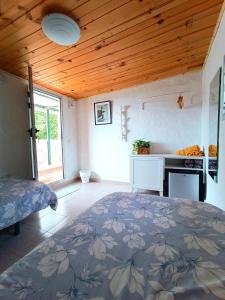 ein Schlafzimmer mit einem Bett in einem Zimmer mit einer Holzdecke in der Unterkunft B&B and Apartments El Charco Azul in El Risco