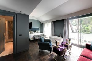 a bedroom with a bed and a living room at Hotel Villa e Palazzo Aminta in Stresa