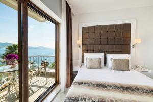 a bedroom with a large bed and a balcony at Elite Hotel Yalıkavak, Bodrum in Yalıkavak +79 photos