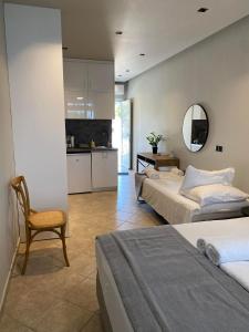 een slaapkamer met twee bedden en een spiegel en een keuken bij Houmas Apartments in Yialós