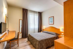una camera d'albergo con letto e scrivania di Hotel Isola Sacra Rome Airport a Fiumicino