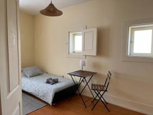 een kamer met een bed, een tafel en een stoel bij Casa do Sete in Vilar do Pinheiro