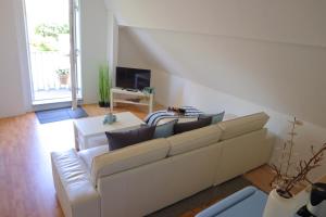 a living room with a white couch and a tv at Watt´n Dog - Urlaub direkt am Nordseedeich in Spieka-Neufeld
