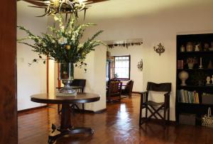 a living room with a table with a vase of flowers on it at Sionsberg Farmstay in Riversdale