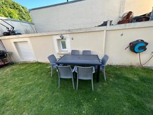 uma mesa preta e cadeiras num quintal em Best holliday Home for family newly renovated em Garges-lès-Gonesse
