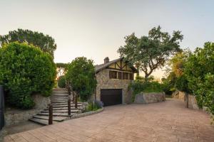 een stenen huis met een garage en een oprit bij For You Rentals Finca Rural el Caribe en Madrid GAM4 in Batres
