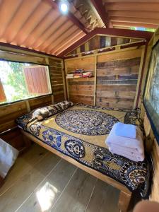 a bed in a room in a log cabin at A Piece of Paradise in San Carlos