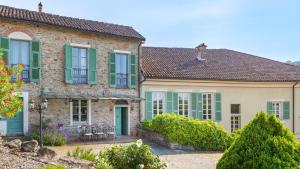 a house with green shutters and a dog on the roof at Villa La Romantica 14, Emma Villas in Grognardo