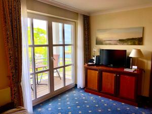 a room with a television and a door to a balcony at Ferienwohnung Seeblick - Insel Usedom in Balm
