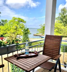 a bottle of water sitting on a wooden table on a balcony at Ferienwohnung Seeblick - Insel Usedom in Balm