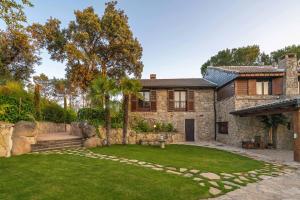 ein Steinhaus mit Garten davor in der Unterkunft For You Rentals Finca Rural el Caribe en Madrid GAM4 in Batres