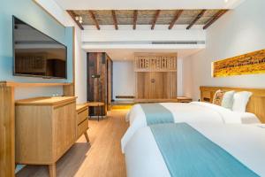 a hotel room with two beds and a television at Yoba Boutique Hotel in Zhangjiajie