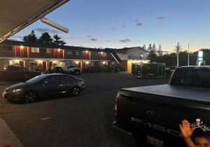 a truck parked in a parking lot with a car at NORTHERN MOTEL in Sault Ste. Marie