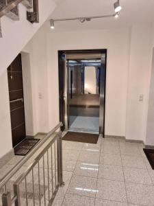 un pasillo con una escalera y un ascensor en un edificio en Luxuriöse 2-Zimmer-Wohnung mit Terrasse, Balkon und Wasserbett, en Garbsen