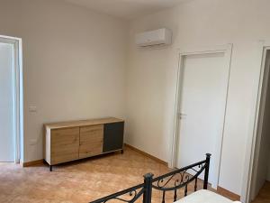 Cette chambre comprend une commode en bois et un placard. dans l'établissement ZEFIRO, à Marsala