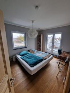 1 dormitorio con 1 cama, escritorio y 2 ventanas en Luxuriöse 2-Zimmer-Wohnung mit Terrasse, Balkon und Wasserbett, en Garbsen