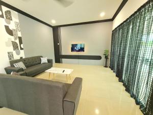 sala de estar con sofá y mesa en Air-home M1 Simpang near Aulong Econsave, 4BR, 10pax, Netflix, en Simpang