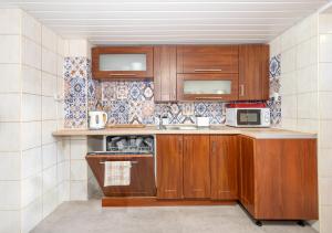 a kitchen with wooden cabinets and a sink and a microwave at Willa Dorotka in Dąbki