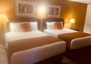 um quarto de hotel com duas camas e duas lâmpadas em NORTHERN MOTEL em Sault Ste. Marie