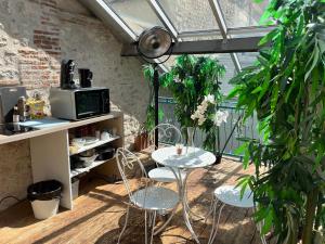 a patio with a table and chairs in a greenhouse at les Pastoureaux in Orléans