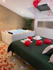 Habitación con bañera de hidromasaje y cama con almohadas rojas. en L'apothéose, appart avec balnéo, en Le Luc