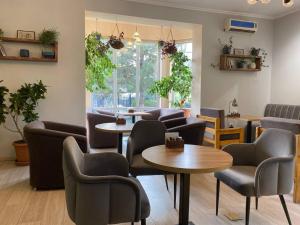 a waiting room with couches and tables and chairs at Silk Road Lodge in Bishkek